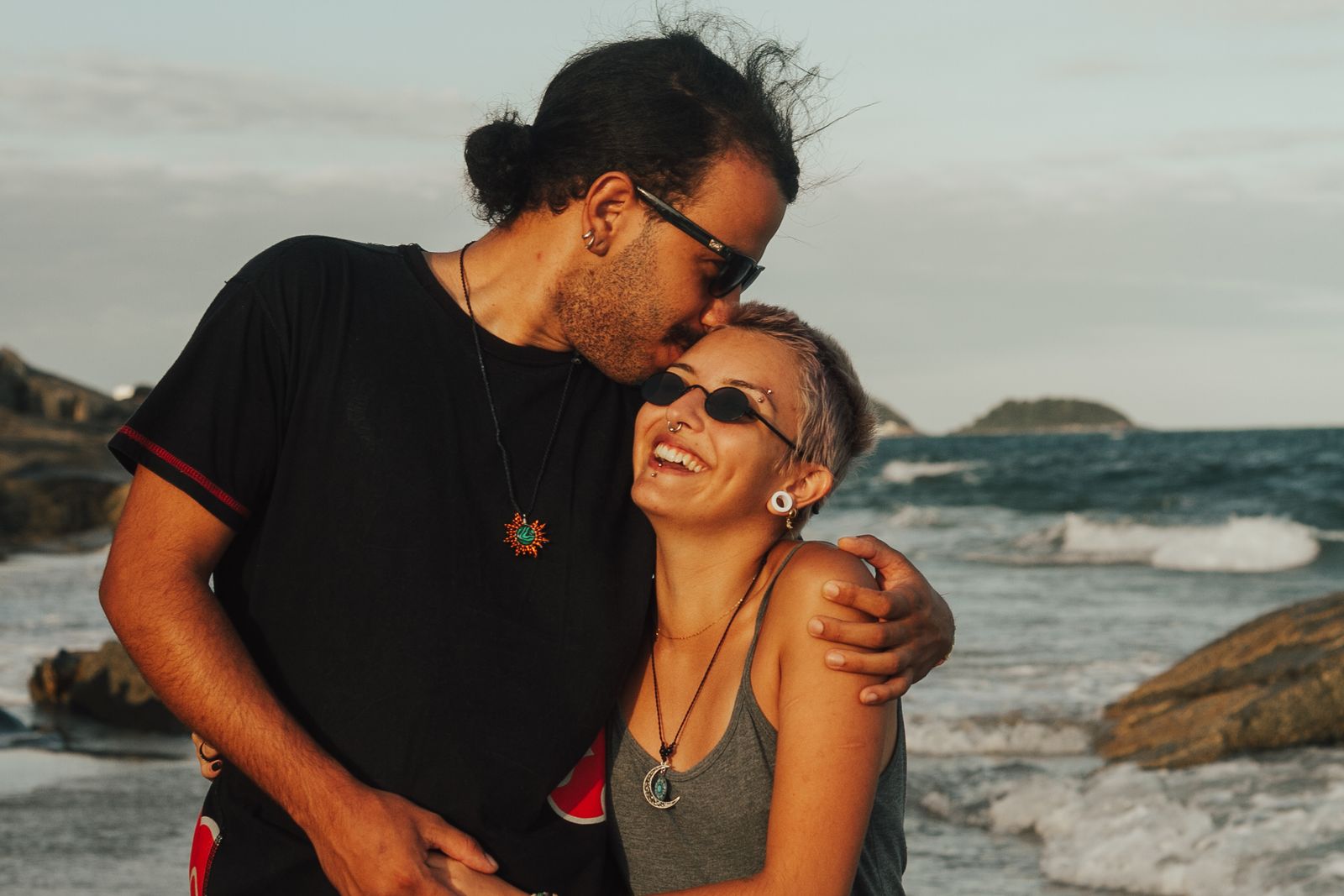 Pareja feliz en la playa al atardecer
